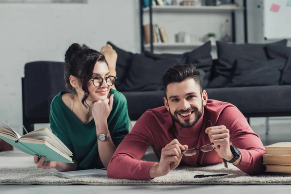 Cheerful Woman Looking Man Lying Carpet Books — Stock Photo, Image