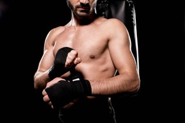 cropped view of shortless sportsman wrapping up gloves isolated on black clipart