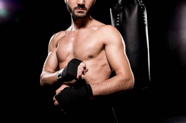 cropped view of shortless athlete wrapping up gloves on black background clipart