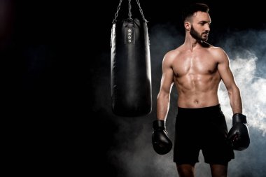 boks eldivenleri kum torbası siyah duman ile yakın duran dalgın atlet