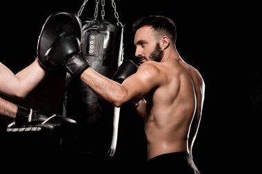 handsome sportsman fighting with man in punching gloves isolated on black clipart