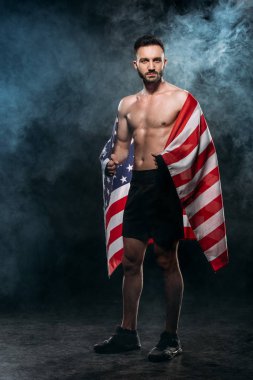 yakışıklı adam siyah duman ile Amerikan bayrağı tutarak