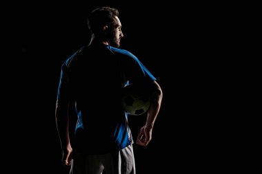 silhouette of muscular sportsman holding ball isolated on black clipart
