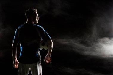 siluet siyah duman ile topu tutan futbolcu  