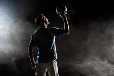 siyah duman ile başının üstünde üniforma holding topu Player'da silüeti  