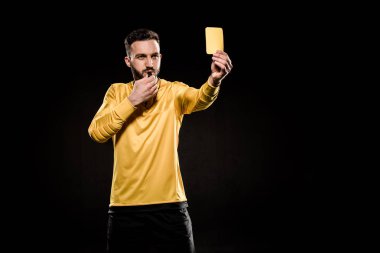sarı kart gösterilen ve siyahta izole düdük üfleme yakışıklı hakem