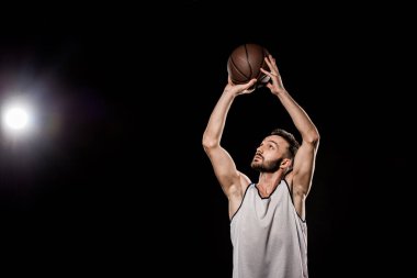 siyah arka plan üzerine topu atma yakışıklı basketbolcu