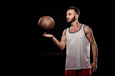 yakışıklı basketbol oyuncu dönen topu siyah izole parmak üzerinde