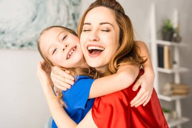 Anne ve çocuk kırmızı pelerinler sarılma yakın çekim