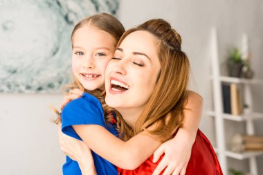 Anne ve kırmızı pelerinler evde çocukta gülümseyerek yakın çekim
