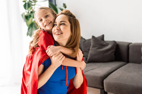 Hija Madre Capas Rojas Abrazándose Sonriendo Casa — Foto de Stock
