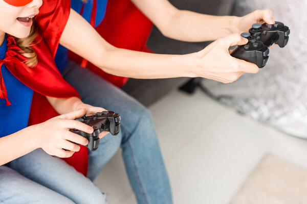 Cropped view of woman and kid playing video game