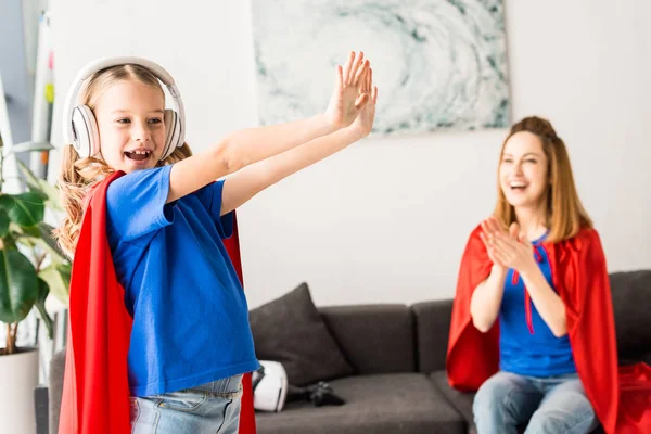 Attraktive Mutter Schaut Tanzende Tochter Mit Weißen Kopfhörern — Stockfoto