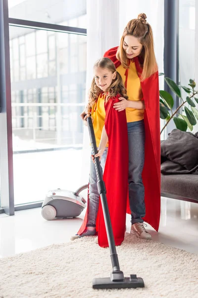 Ibu Dan Anak Dalam Jubah Merah Dengan Vacuum Cleaner — Stok Foto