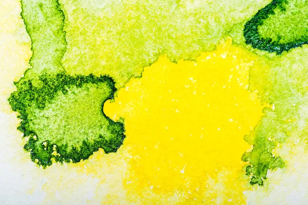 白い紙にコピー スペースで黄色と緑の水彩流出のトップ ビュー — ストック写真
