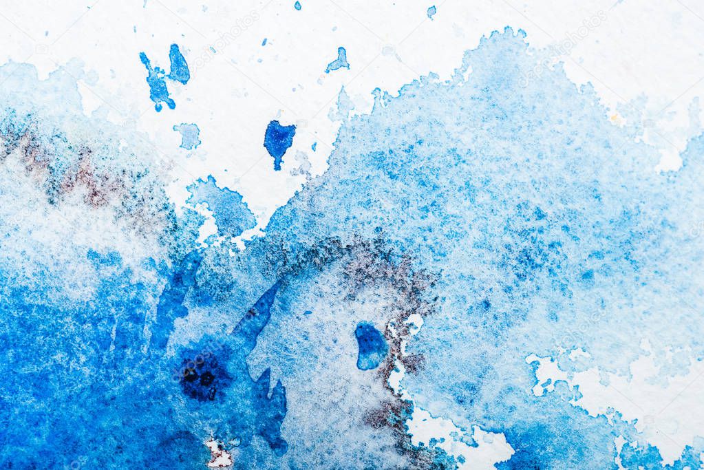 top view of blue watercolor spill on white paper