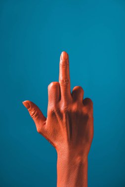 cropped view of woman showing middle finger on coral colored hand on blue background,  color of 2019 concept clipart