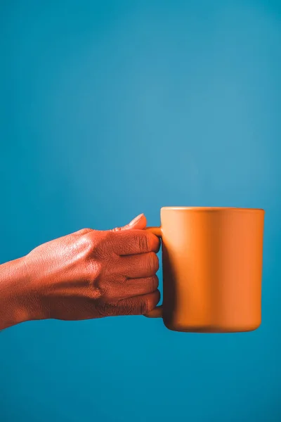 青の背景 2019年コンセプトの色にサンゴ色の女性の手とカップの部分ビュー — ストック写真