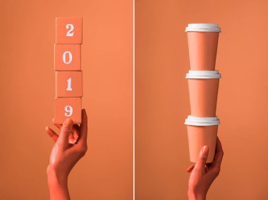 mercan ahşap küpleri 2019 numaraları ve mercan kağıt bardak bölünmüş mercan arka plan, renk 2019 kavramının kadın elinde yığını ile