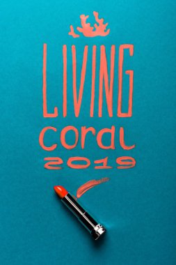 color of year 2019 handwritten lettering with coral lipstick on blue background clipart