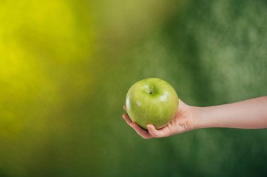 Çocuk el apple ile kısmi görünümü arka plan bulanık, dünya gün kavramı üzerinde