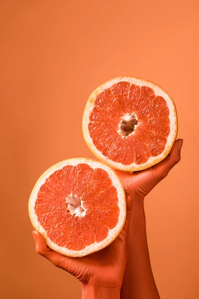 Partial View Coral Colored Female Hands Grapefruit Halves Coral Background — Stock Photo, Image