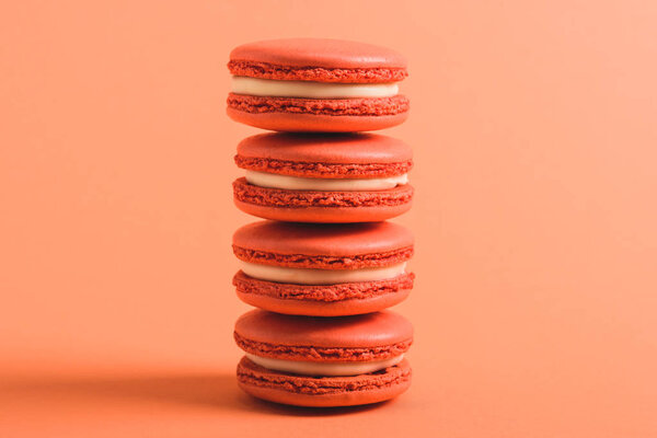 stack of coral macarons on coral background, color of 2019 concept