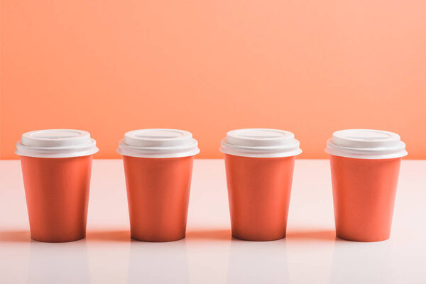 coral disposable cups on coral background, color of 2019 concept