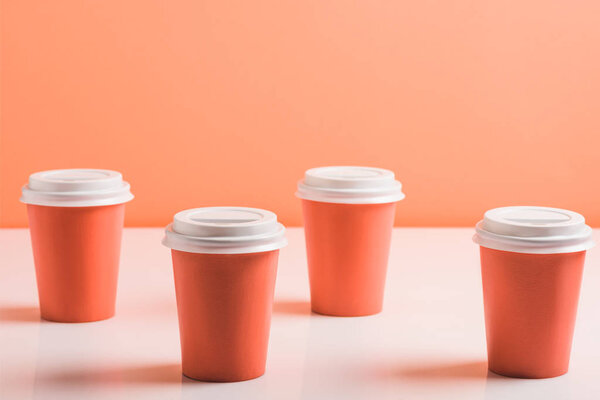 coral disposable cups on coral background, color of 2019 concept