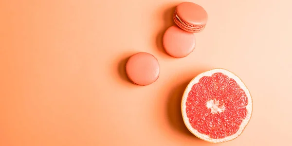 Bovenaanzicht Van Koraal Macarons Grapefruit Helft Koraal Achtergrond Kleur Van — Stockfoto
