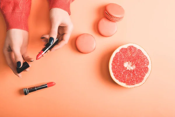 Cropped View Woman Holding Coral Lipstick Macarons Grapefruit Half Coral — Stock Photo, Image