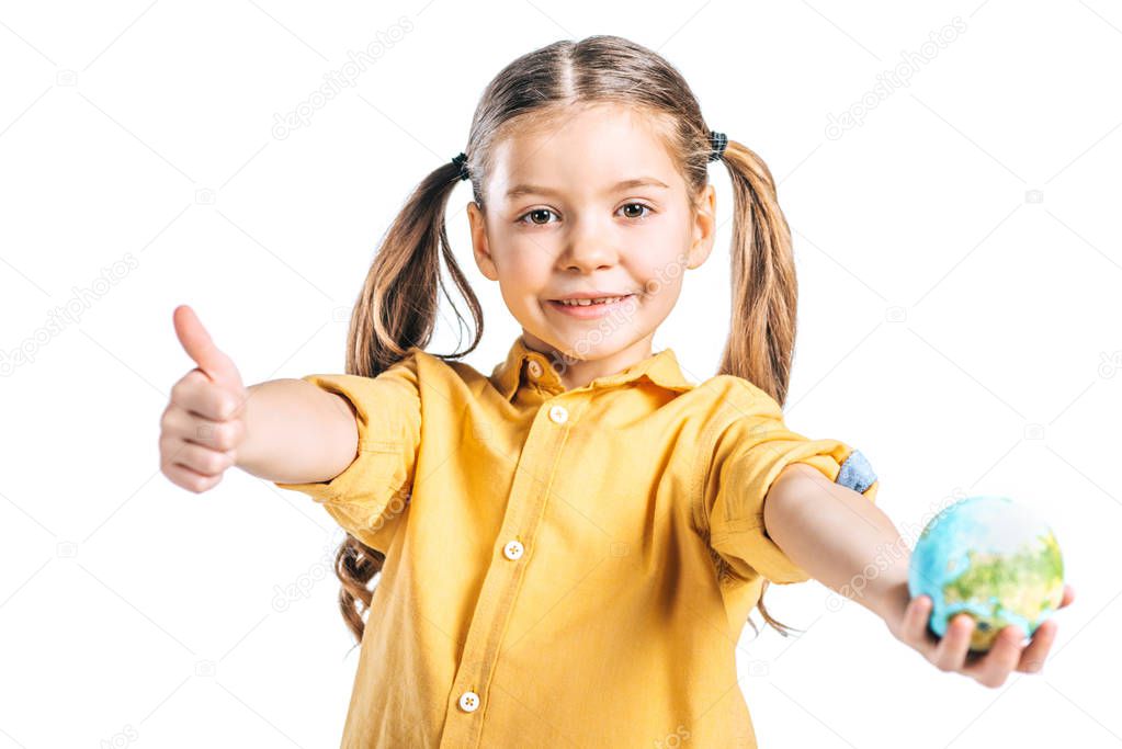 smiling kid holding globe model and showing thumb up isolated on white, earth day concept