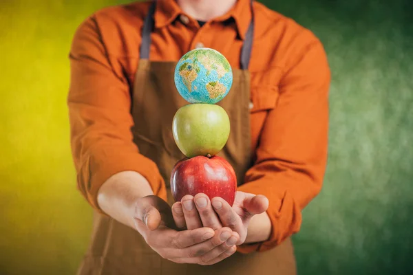 背景をぼかし 地球日コンセプトにリンゴと世界モデルを保持している人間の選択と集中 — ストック写真