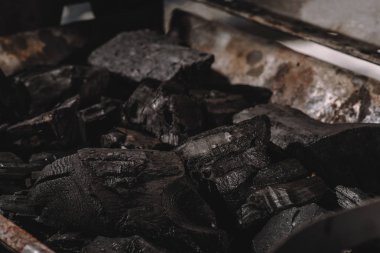 selective focus of dark black coals in barbecue  clipart