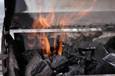 bright burning black coals in iron barbecue grill clipart
