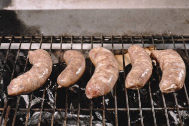 Barbekü ızgara yemek ham taze sosis kömürlerin yanma ile rendeleyin