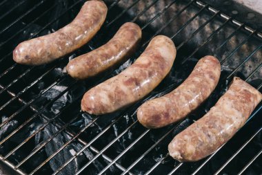 Barbekü üzerinde hazırlanıyor pişmemiş taze sosis ızgara ızgara
