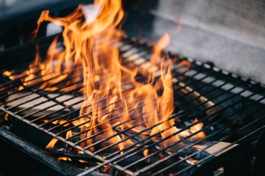 burning firewood with flame through bbq grill grates clipart