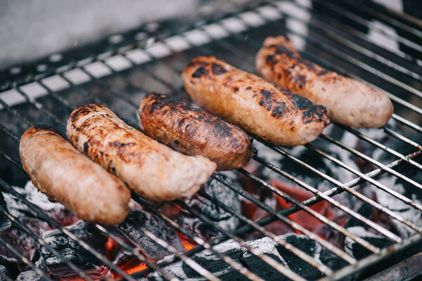 selective focus of grilled delicious sausages on bbq grid