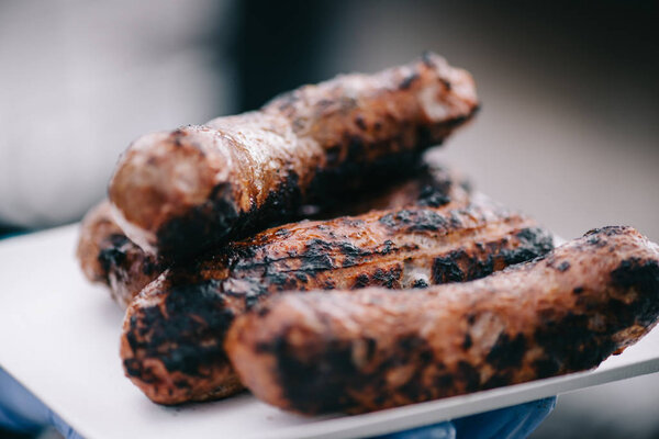 selective focus of delicious meat sausages with crust on white plate 