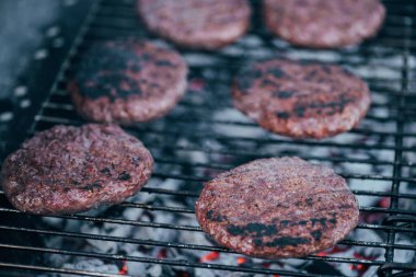 selective focus of grilled fresh burger cutlets on bbq grid clipart