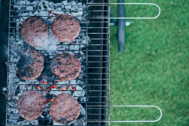 top view of grilled fresh tasty burger cutlets on bbq grid clipart