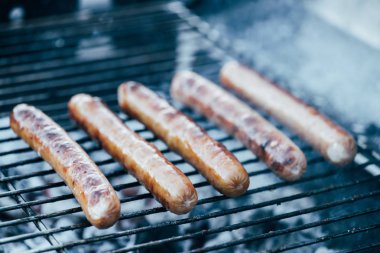 selective focus of tasty grilled sausages on bbq grill grade clipart