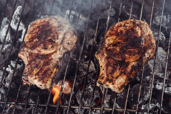 juicy delicious steaks grilling on barbecue grill grade with smoke
