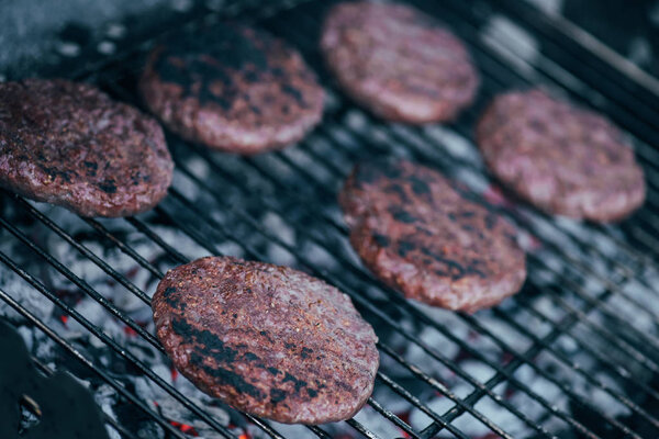 selective focus of grilled fresh burger cutlets on bbq grid