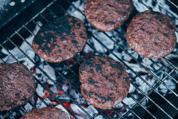 top view of grilled fresh burger cutlets on bbq grid