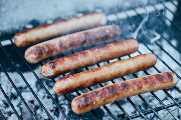 selective focus of tasty grilled sausages on bbq grill grade