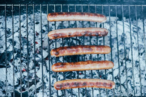 Widok Góry Smaczne Kiełbaski Grilla Bbq Grill Klasy Tle Zielonej — Zdjęcie stockowe