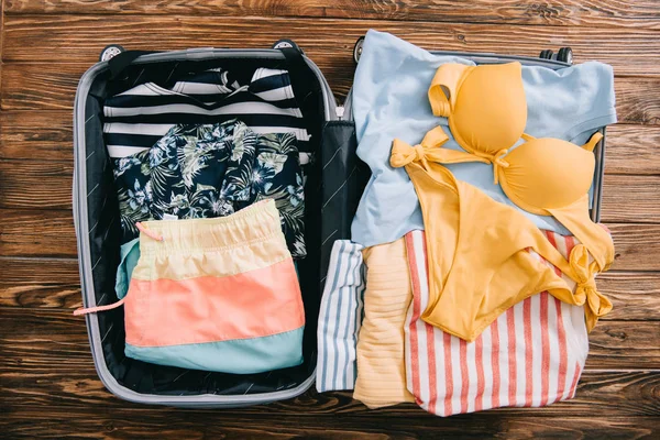 Bovenaanzicht Van Zomer Kleren Een Koffer Houten Achtergrond — Stockfoto