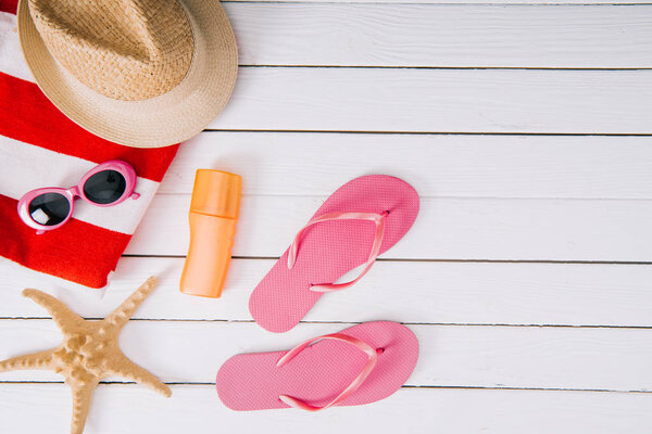top view of sunscreen, starfish and summer accessories on white wooden background 